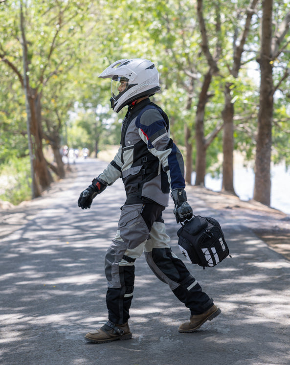 Integrated Grab Handle Person in full motorcycle gear walking on a road with trees in the background