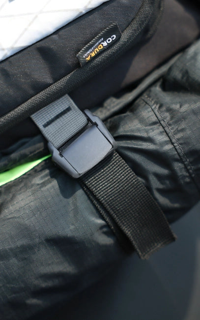 Cam-Lock Adjustment Close-up of a black strap with a brand label on a dark fabric background