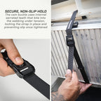 Black strap with cam buckle being used to secure a vehicle roof rack.