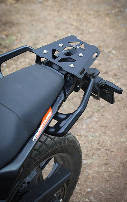 Designed for QUICK MOUNT REAR RACK - KTM ADV 390 Gen2 (2025>) Close-up of a motorcycle seat and rear rack on a textured surface