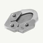 A metallic silver metal shoe clip with three adjustable screws and a small engraved logo, shown on a light off-white background.