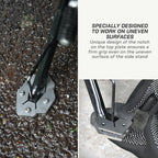 A metal ground anchor with a hexagonal base and angled prongs is shown outdoors on wet pavement, with a second view of a gloved hand inserting a tool into the anchor. Text on the right explains that the design is specially designed to work on uneven surfaces.
