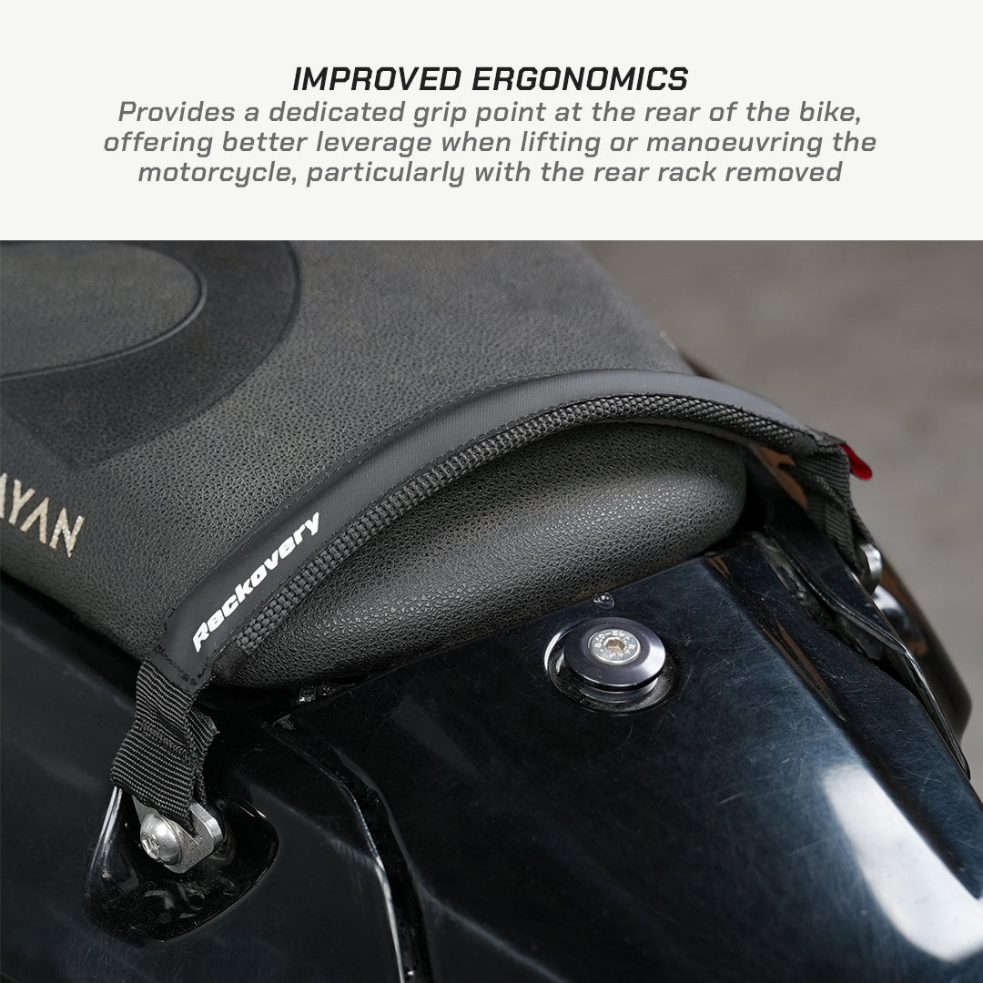 color_black Close-up of a black motorcycle seat pad with a textured grip point and a strap attachment, shown on a motorcycle with text at the top describing improved ergonomics.