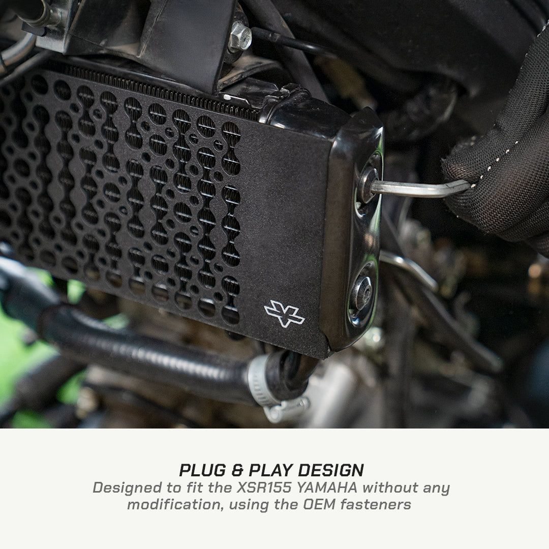 color_black Close-up of a black motorcycle accessory mounted over a radiator, with text at the bottom reading 'PLUG & PLAY DESIGN' and 'Designed to fit the XSR155 YAMAHA without any modification, using the OEM fasteners.'.