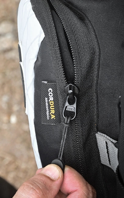 Genuine YKK Zippers Close-up of a black Cordura material label on a bag with a blurred background.