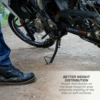 color_common Motorcycle with a foot peg and person wearing boots on a dirt surface, emphasizing stability.