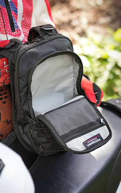 High-Visibility Interior A close-up of a black Verveva motorcycle fanny pack with its front zippered pocket open, resting on a black motorcycle seat outdoors.