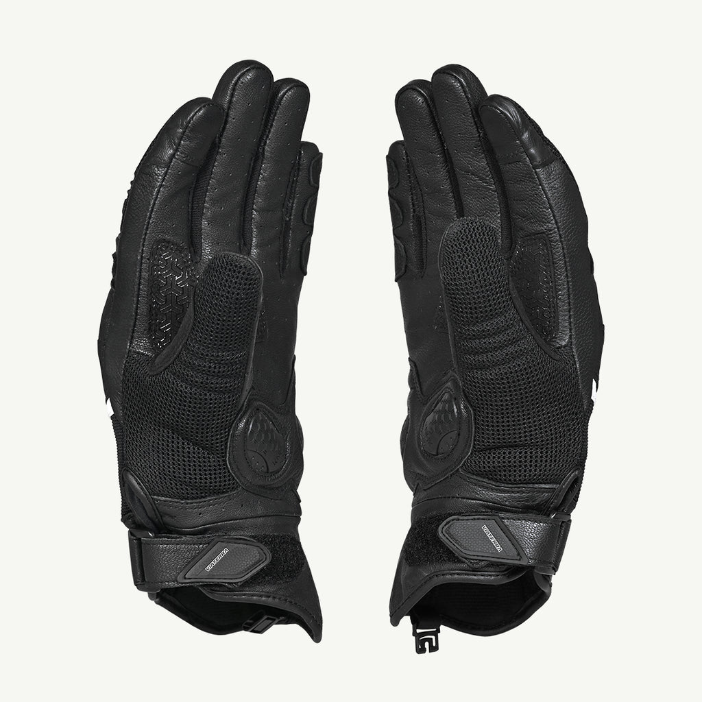 color_common Pair of black gloves with textured palm and wrist closures on a light gray background