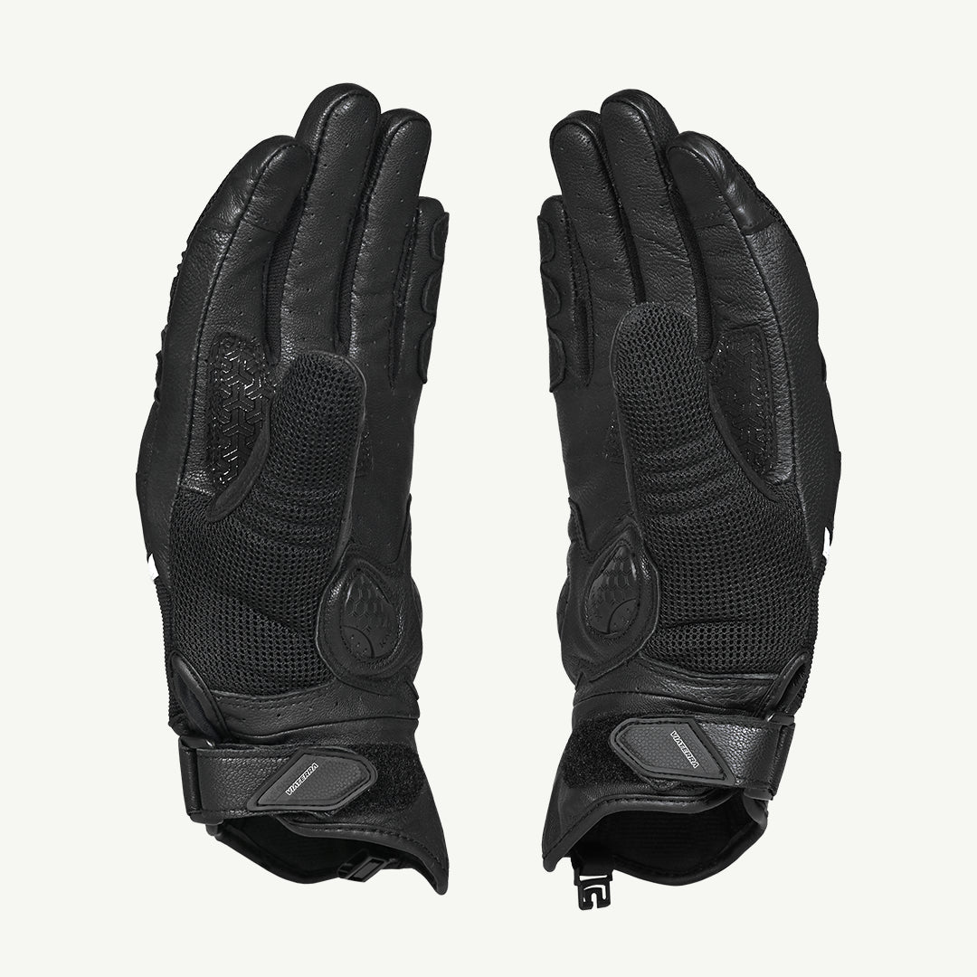 color_common Pair of black gloves with textured palm and wrist closures on a light gray background