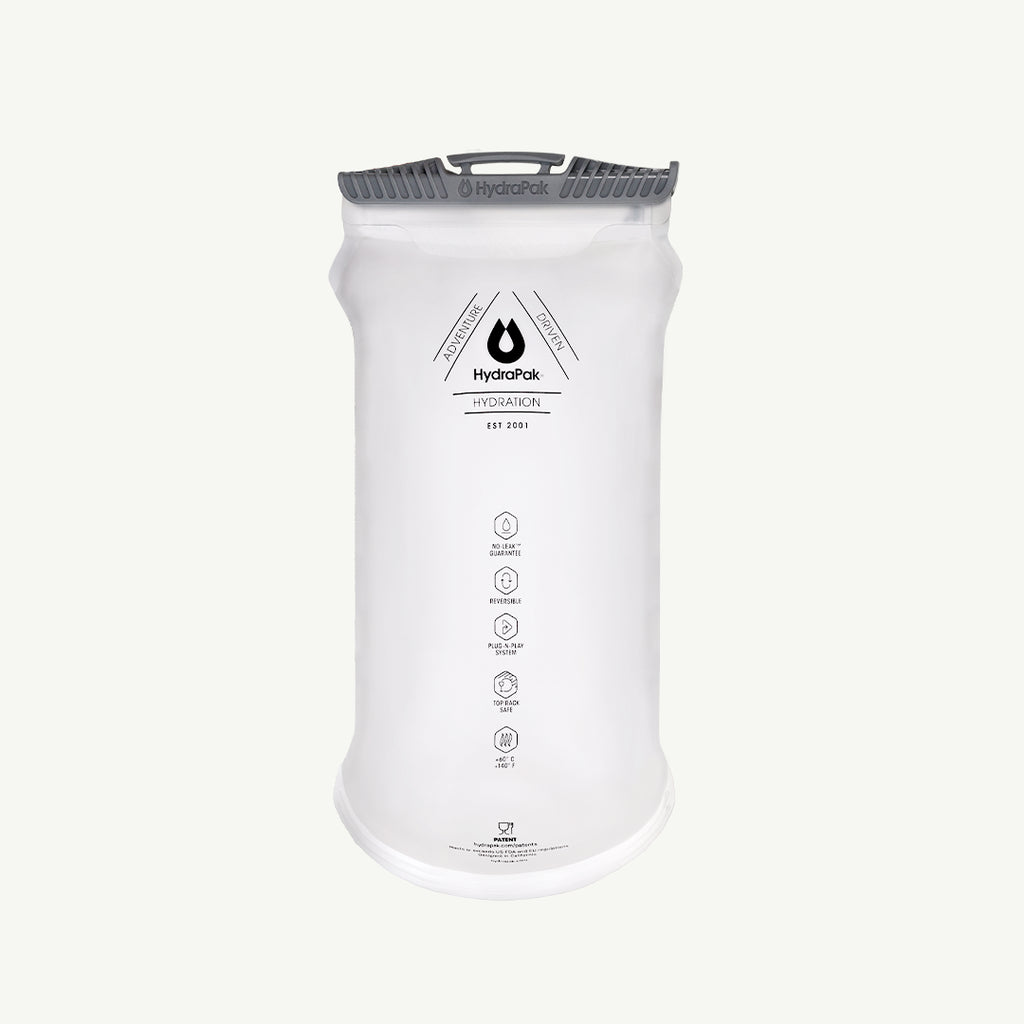 A white HydroPak Hydration 3-liter water bag with a gray quick-release strap and handle, shown on a light off-white background.