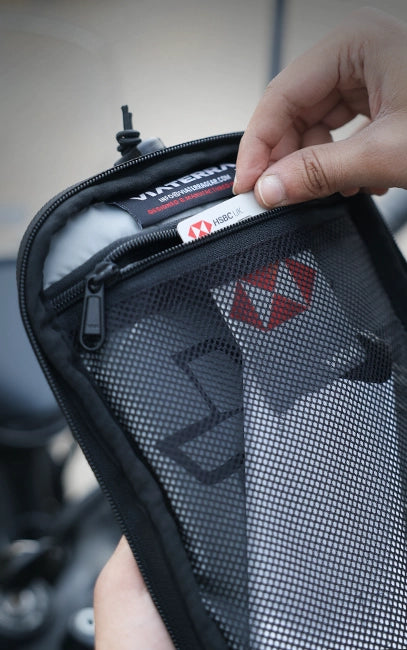 Lid Mesh Pocket Person holding a black mesh pouch with visible branding.