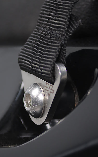 Premium build and finish Close-up of a black woven strap attached to a silver metal buckle with a hex screw, set against a dark black background.