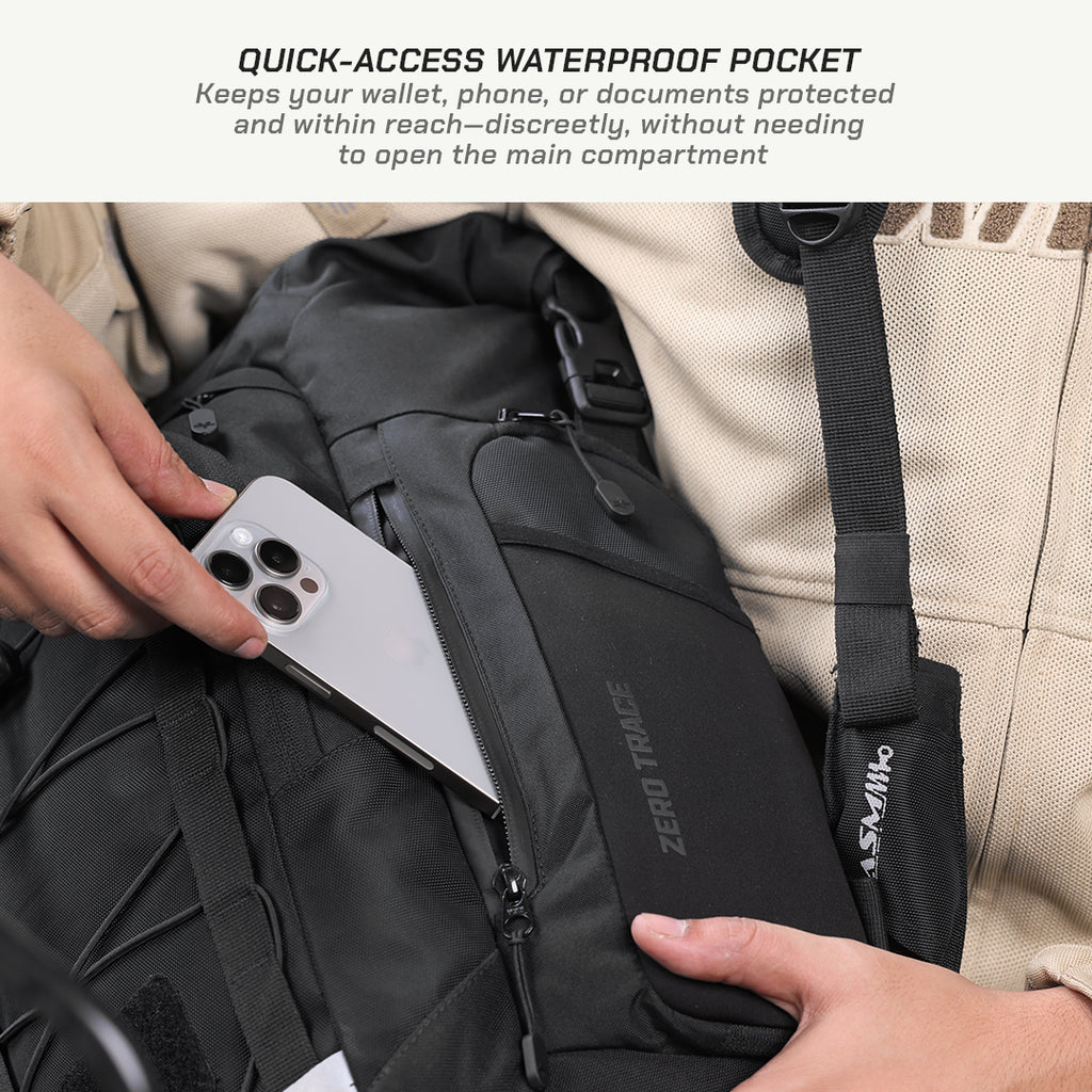 Close-up of a black backpack with a quick-access waterproof pocket being used to store a silver smartphone. A person's hands are visible holding the phone and adjusting the strap, with a beige jacket in the background.