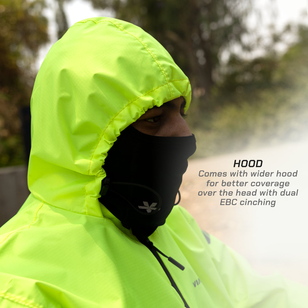 color_Fluoroscent-Green Person wearing a bright yellow raincoat with a black hood, standing outdoors.