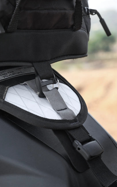 Reinforced Rear Latch Close-up of a black backpack with straps on a blurred natural background