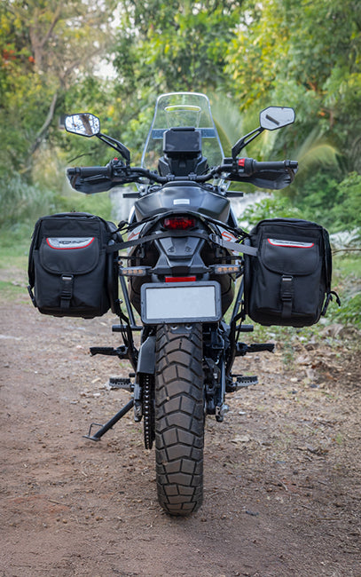 Safety Clearance Motorcycle with saddlebags on a dirt road surrounded by trees
