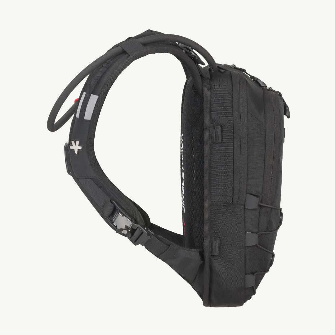 A black technical running backpack shown from a side profile view against a solid off-white background. The backpack features a padded shoulder strap, compression buckles, and multiple zippered compartments.