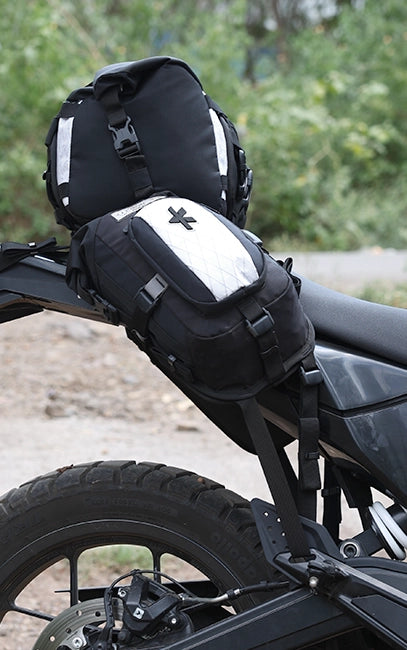 Triangular 3-Point Mount Black motorcycle saddlebags attached to a bike with a blurred natural background