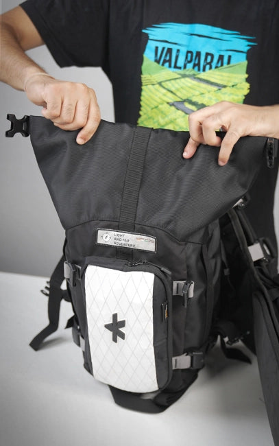 Waterproof Roll-Top System Person holding a black and gray backpack with visible branding on a light gray background