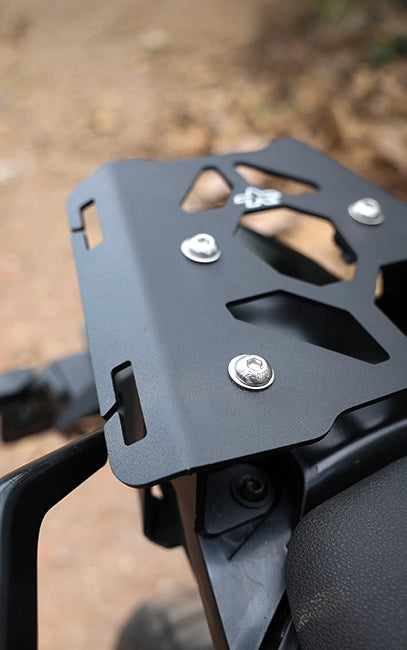 Wide slots for easy use Close-up of a black metal motorcycle luggage rack with screws on a blurred natural background