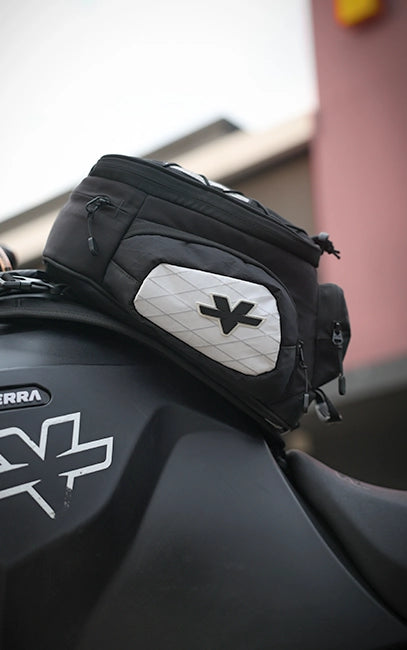 X-Pac Pocket Panels Black motorcycle saddlebag with a brand logo attached to a motorcycle.